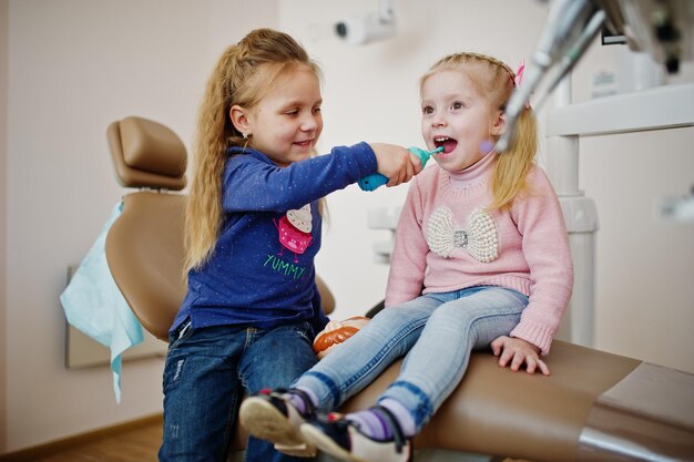 Zwei süße kleine Mädchen am Zahnarztstuhl Kinder zahnärztlich