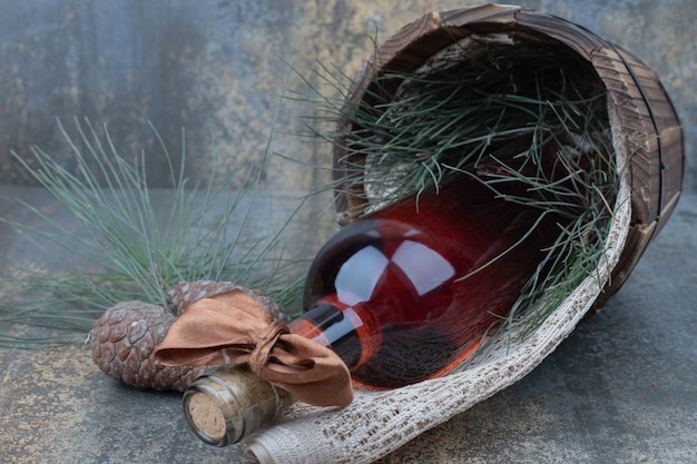 Zwei Tannenzapfen mit Flasche Wein auf Marmorhintergrund. Hochwertiges Foto