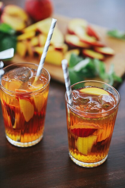 Zwei Tassen gelber Pfirsichsaft auf dem Holztisch