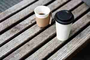 Kostenloses Foto zwei tassen kaffee-to-go stehen auf holzbank