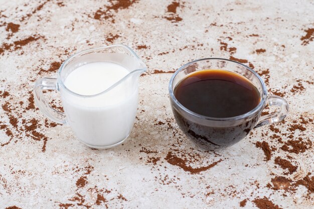 Zwei Tassen Milch und Tee auf einer Marmoroberfläche