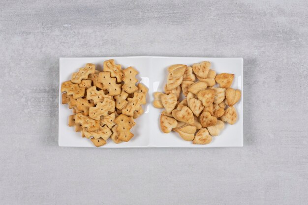 Zwei verschiedene Arten von Crackern auf weißem Teller.