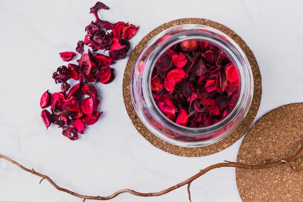 Zweig nahe Glas mit den Blumenblättern