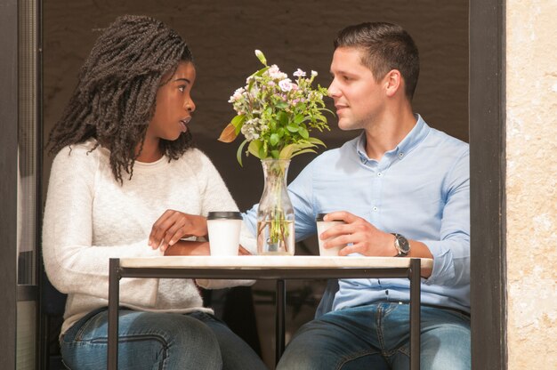Zwischen verschiedenen Rassen Paare, die im Café argumentieren