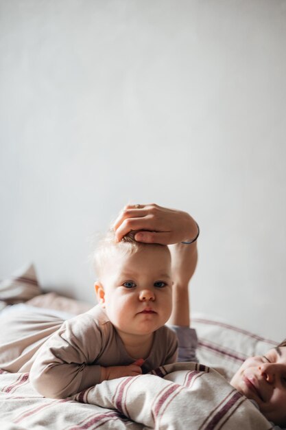 Foto 02032022 vinnitsa ucrânia jovem mãe e filha acordaram na cama se divertindo abraçando olhando para um livro