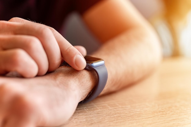 0232022 Moskau männliche Hand mit einem Handgelenk Smart Apple Watch junger Mann Menschen mit moderner Technologie durch Anpassen und Einstellen der Uhrzeit auf der Uhr durch Berühren des digitalen Bildschirms mit seinen Fingern flackern
