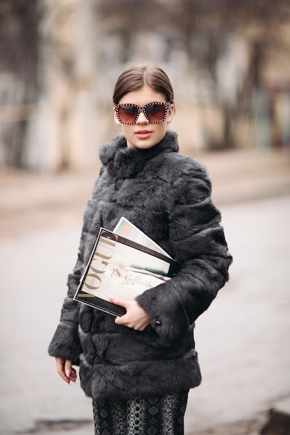 03 18 2019 Bielorrusia Minsk Mujer de moda con abrigo de piel y gafas de sol posando en la calle