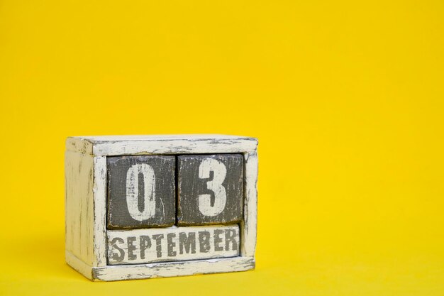 03 de septiembre calendario de madera con fondo amarillo con un espacio vacío para texto