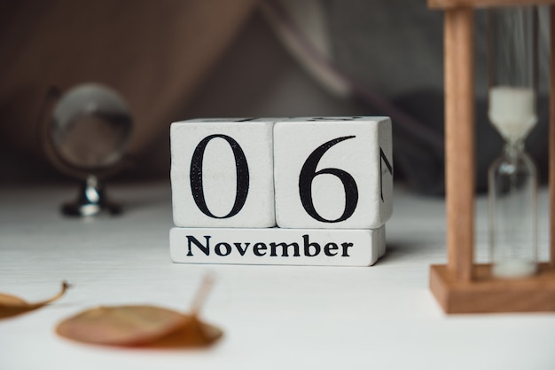 06 de novembro em calendário feito de cubos brancos na mesa branca