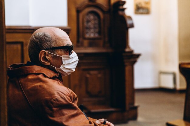07062020 Vinnitsa Ucrânia um velho careca de óculos e uma máscara protetora arriscando sua vida veio à igreja para liturgia durante uma epidemia viral