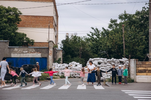 070722 Irpin Ucrania los niños y sus maestros caminan en parejas sosteniendo un bolígrafo y se esconden en una barricada hecha de sacos de arena durante una advertencia de ataque aéreo