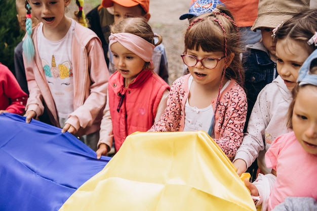 070722 Irpin Ukraine Christlicher Kindergarten Kinder mit der ukrainischen gelbblauen Flagge in der Hand beten für die Ukraine und den Frieden