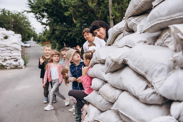 070722 Irpin Ukraine Kinder verstecken sich bei Fliegeralarm in einer Straßensperre aus Sandsäcken