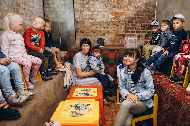 070722 Irpin Ukraine Kleinkinder und ihre Betreuer werden während eines Luftangriffs in einen unterirdischen Keller evakuiert, der als Unterschlupf dient