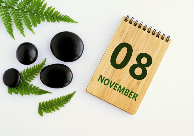 08 de noviembre 08 día del mes calendario fecha Bloc de notas negro SPA piedras hojas verdes Mes de otoño día del año concepto