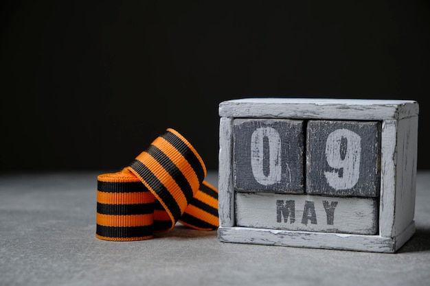 09 de maio calendário de madeira e fundo preto da fita St GeorgeConcept para o dia da vitória sobre o fascismo