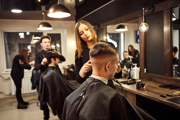 09. Februar 2021 Vinnitsa Ukraine Salon Mann in einem Friseurstuhl Der Friseur bedient den Kunden im Friseursalon Das Konzept der männlichen Kosmetologie