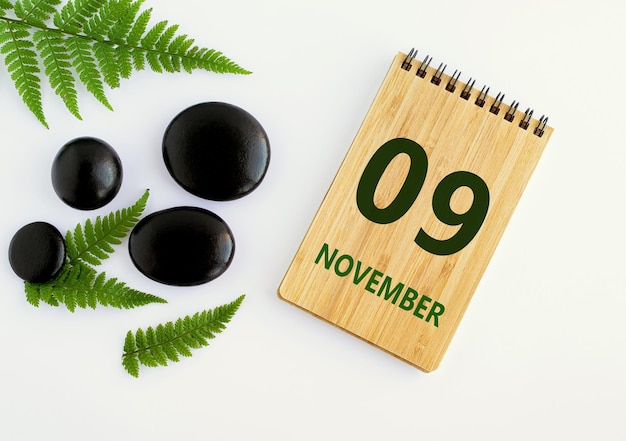 09. November 09. Tag des Monats Kalenderdatum Notizblock schwarz SPA Steine grüne Blätter Herbstmonat Tag des Jahres Konz