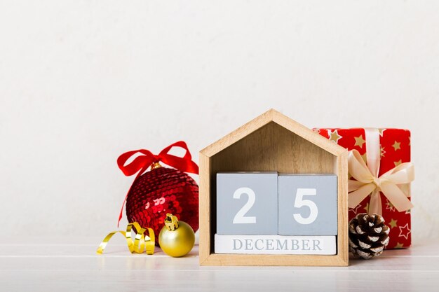 1º de janeiro Composição de Natal em fundo colorido com um calendário de madeira com uma caixa de presentes brinquedos espaço para cópia de bugigangas