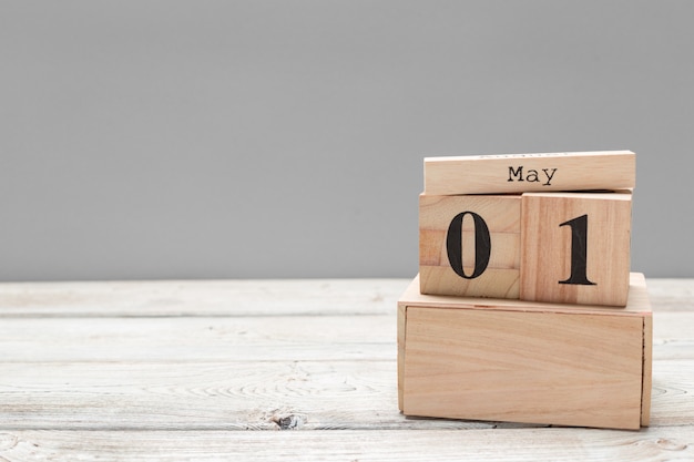 1. Mai. Bild vom 1. Mai hölzernen Farbkalender auf Holztisch. Frühlingstag, leerer Platz für Text. Internationaler Tag der Arbeit