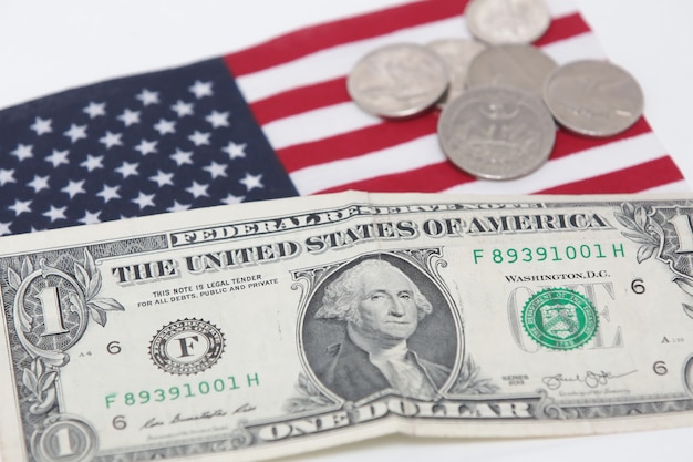 1 nota de dólar dos Estados Unidos com moedas e bandeira na parte inferior