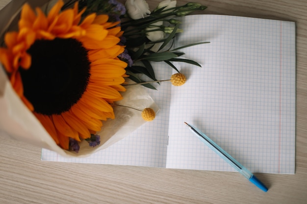 1 de septiembre Concepto de regreso a la escuela Ramo con girasol y útiles escolares en la mesa