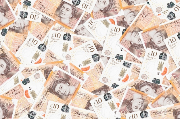 10 britische Pfund Rechnungen liegen in großen Haufen. . Großer Geldbetrag