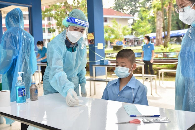 10 de novembro de 2021; Chiang Rai, Tailândia: Os professores usam kits de antígeno de autoteste rápido. (atk) Teste Covid-19 para alunos