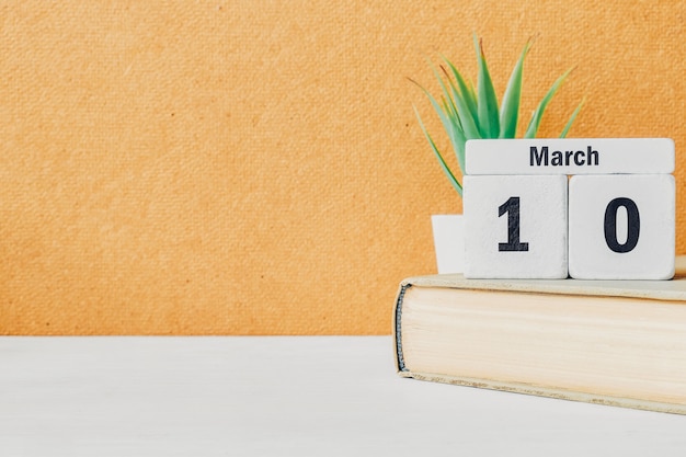 10 décimo día de marzo en el calendario con libro y planta.