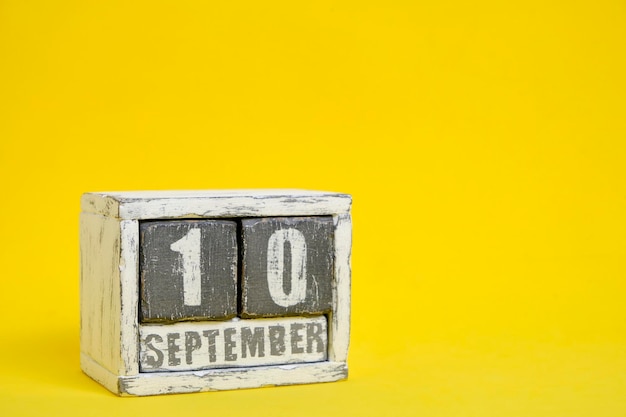 10 de septiembre calendario de madera de fondo amarillo con un espacio vacío para el texto