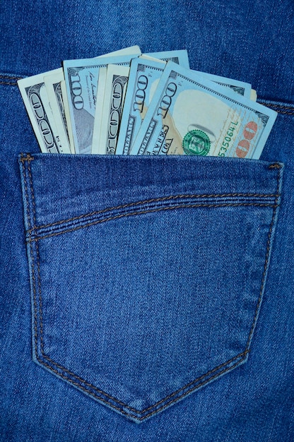 100-Dollar-Scheine, die aus einer Jeanstasche ragen.