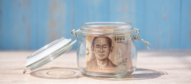 1000 billetes de baht tailandés en frasco de vidrio. Dinero, negocios, inversiones