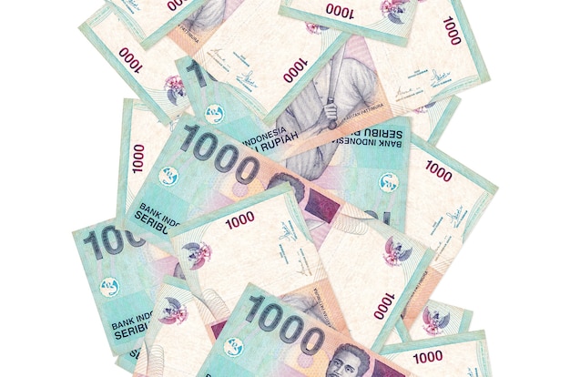 1000 billetes de rupia indonesia volando hacia abajo aislado en blanco. Muchos billetes caen con espacio de copia en blanco en el lado izquierdo y derecho