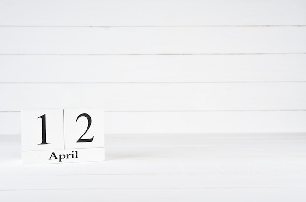 12 de abril, día 12 del mes, cumpleaños, aniversario, calendario de bloques de madera sobre fondo de madera blanco con espacio de copia de texto.