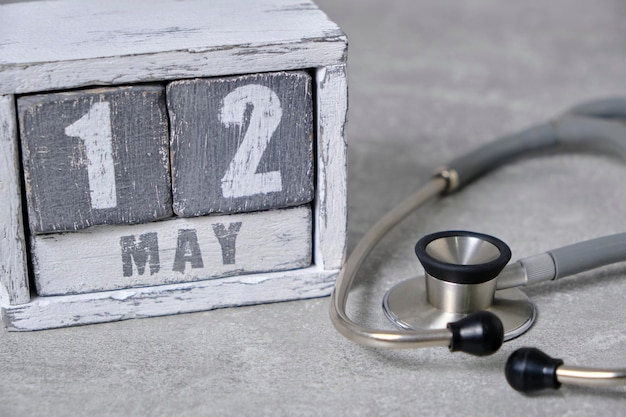12 de maio calendário de madeira e estetoscópio em backgroundConcept cinza para o dia da enfermeira