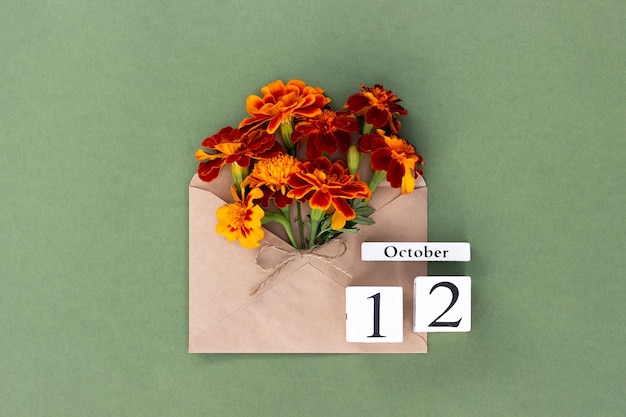 12 de outubro Buquê de flor de laranjeira em envelope de artesanato e data de calendário em fundo verde Conceito mínimo Olá modelo de outono para seu cartão de saudação de design