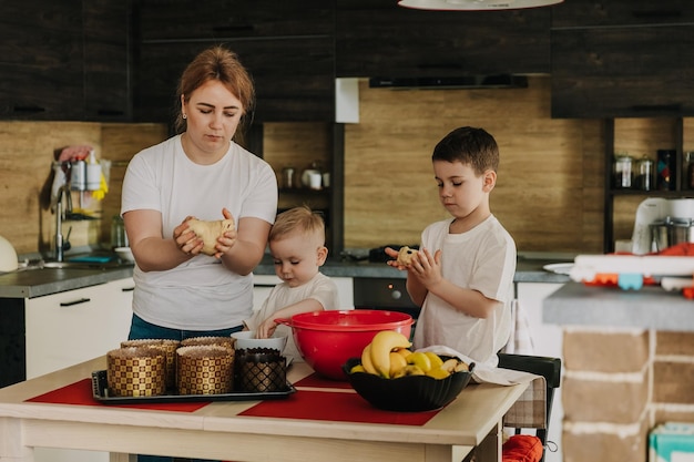 18112018 Vinnitsa Ucrania dos hermanitos jugando en casa corriendo por la cocina ayudando a mamá a cocinar jugando juegos caseros