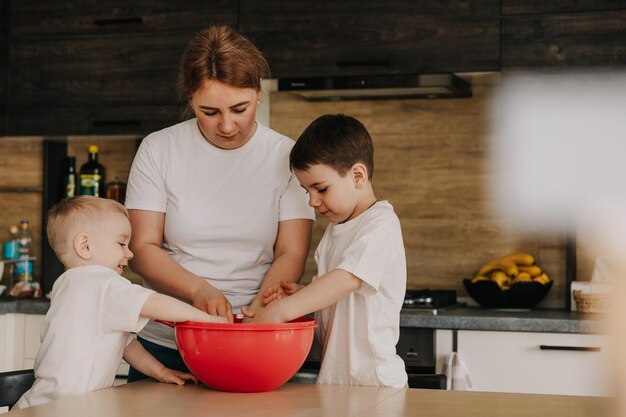 18112018 Vinnitsa Ucrania dos hermanitos jugando en casa corriendo por la cocina ayudando a mamá a cocinar jugando juegos caseros