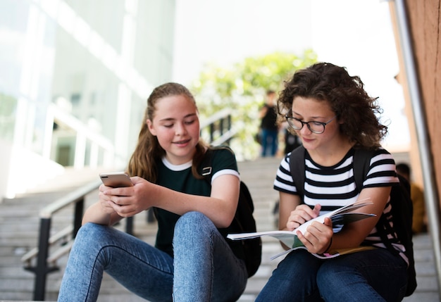 2 alumnas leyendo en las escaleras.