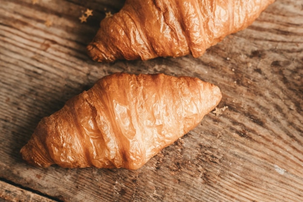 2 croissants grandes sobre un fondo de madera Desayuno matutino en Francia