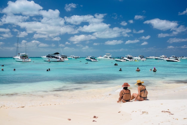 2 garotas sensuais senhoras estão sentadas em biquíni brasileiro em uma praia de areia branca mar turquesa do caribe Isla Mujeres ilha Mar do Caribe Cancun Yucatan México