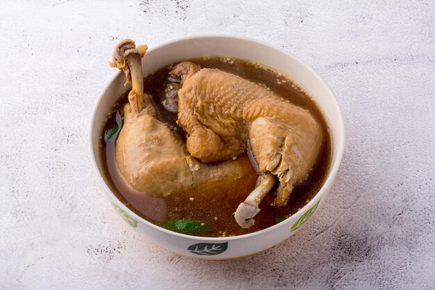 2 große Hühnerbeinviertel Hühnersuppe in Schüssel auf dem Tisch, Ansicht von oben.