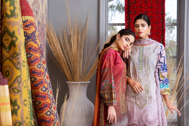 Foto 2 paisaje de chicas asiáticas calientes de pie juntas con vestidos tradicionales y joyas