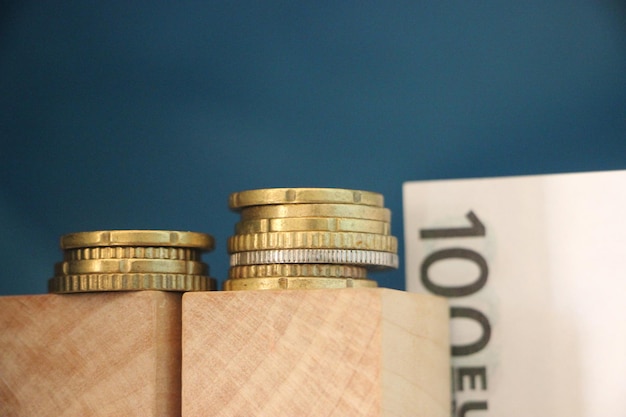 2 pilas de monedas de euro y billete de 100 euros concepto de beneficio empresarial