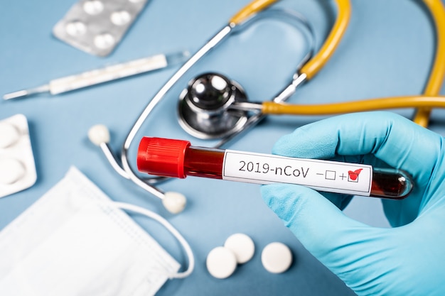 2019-nCoV. Der Arzt hält ein Reagenzglas mit Blut in der Hand. Ein positiver Bluttest für ein neues Coronavirus.