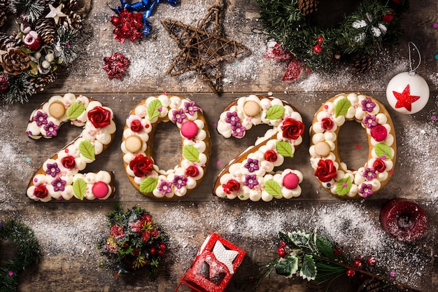 2020 bolo e enfeites de Natal na mesa de madeira. Ano novo conceito.