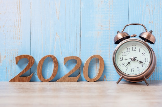 2020 feliz año nuevo con despertador retro y número de madera.