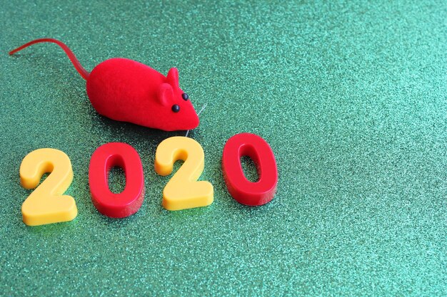 2020 Neujahrszahl und ein Spielzeug rote Maus auf einem grünen