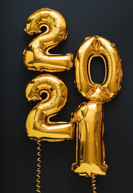 2021 Frohes neues Jahr Gold Luftballons Text auf schwarzem vertikalen Format.