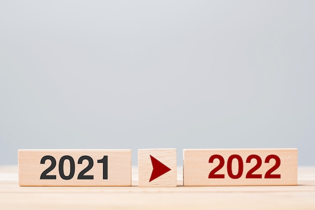 2021 und 2022 Holzblock auf Tischhintergrund. Konzepte für Vorsatz, Strategie, Countdown, Ziel, Veränderung und Neujahrsferien